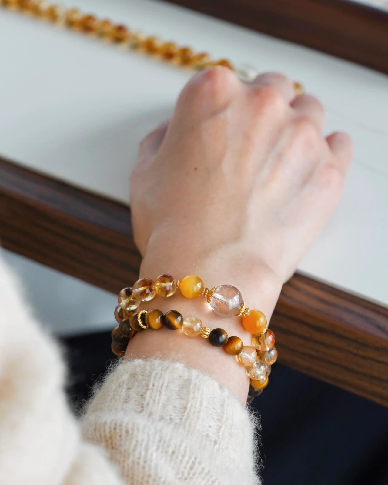 Wrist-angle close-up—citrine beaded bracelet with rutilated quartz and tiger’s eye accents, stacking style for subtle protection and optimism.