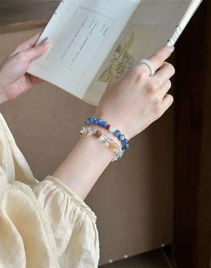 Reading a book while wearing the kyanite, quartz, sandalwood, red agate and nephrite Elemental Alignment bracelet.